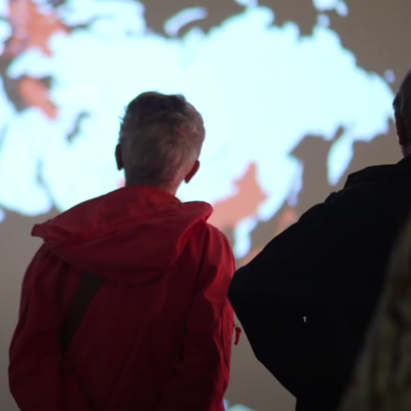 Deux visiteurs devant la planisphère projeté 
