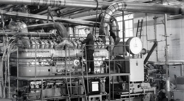 Photographie d’un apprenti diéséliste au banc d’essais des moteurs AGO prise par Patrick Perrot en 1968 conservée aux archives de Mulhouse. 