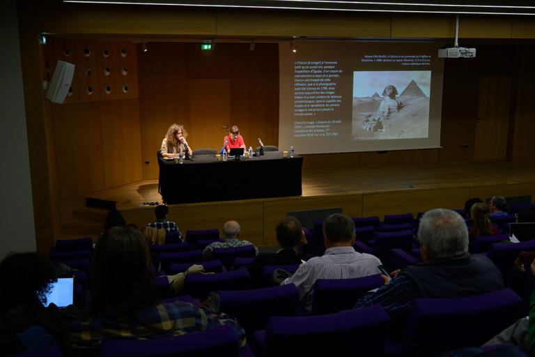 La scène de l'auditorium avec deux intervenants et une projection 